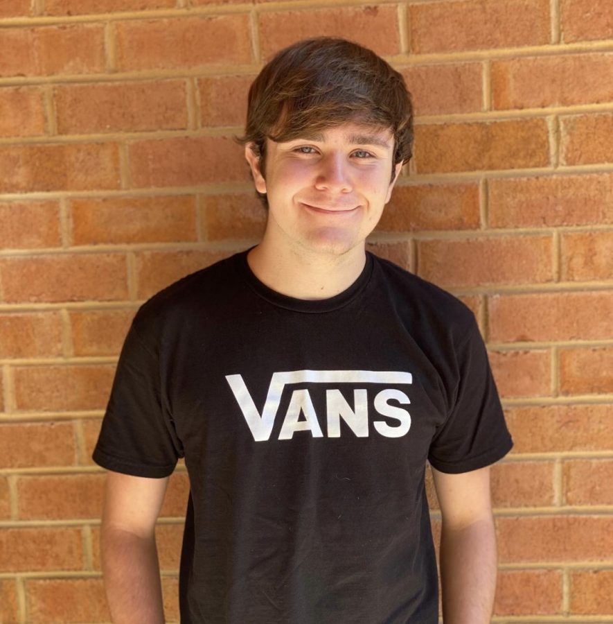 Alexander Wilson stands in front of a brick wall