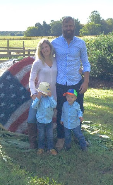 Luechauer and her family stand outside in front of a bale of hay with the American flag painted on it.