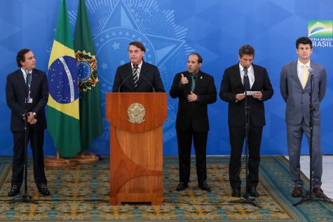Brazilian politicians standing in line behind a podium.