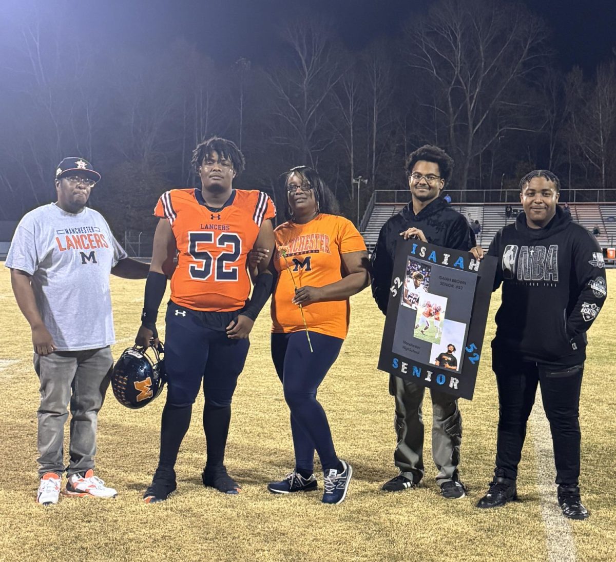 Surrounded by family and friends, Isaiah Brown walks across the field on Senior Night.